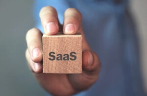 Businessman showing SaaS word on wooden cube. United States | The Great SaaS Consolidation